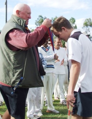 Our young gun: Alex Gorham receives his Premiership medal from Ralph Barron.