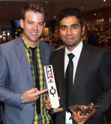 Firsts captain Matt Thomas looks on as Khalid Hassan shows off his miniature bat award for scoring a century, and his First Eleven batting averages award.