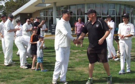 Ian Denny (left) is congratulated by the only other Moonee Valley player to reach 300 games, Darren Nagle. Teammates and supporters celebrate the moment.