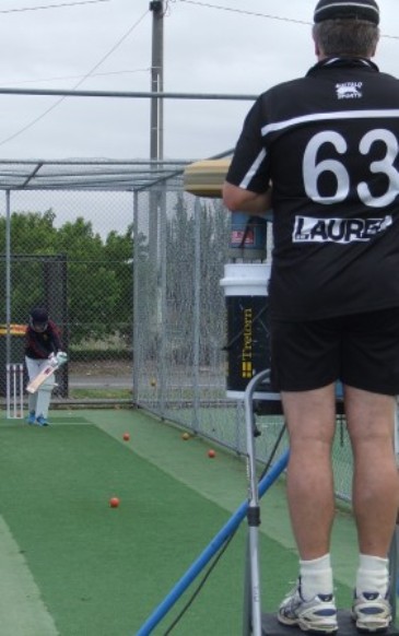 Senior wicketkeeper Peter Golding feeds the bowling machine as Bevan Holder bats.