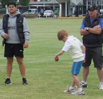 Zac Nilsson marks out his bowling runup, watched by Firsts quick bowler Chris Pollock and junior coach Tony Nilsson.