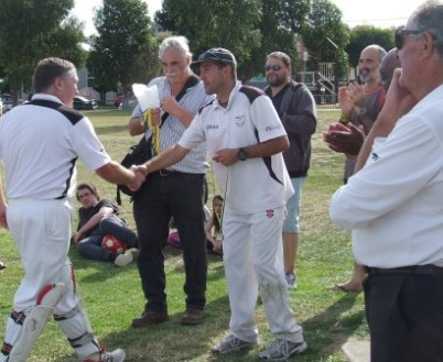 Well kept, young man! Peter Golding is still in his keeper's pads as he walks up to receive his Premiership Medallion from captain Jim Polonidis.