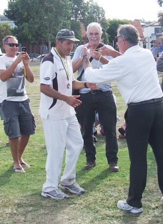 Captain Jim Polondis receives his Man of the Match medal from umpire Brian Lazzaro.