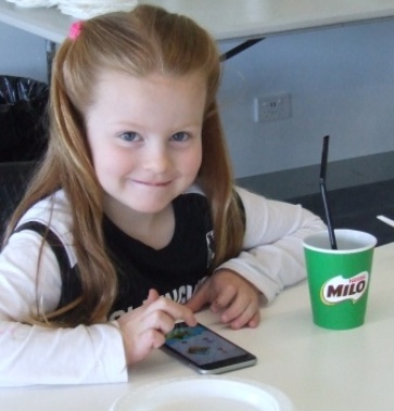 Hey Dad, where's the Magpies? Marley Gauci tries to check the Collingwood score.