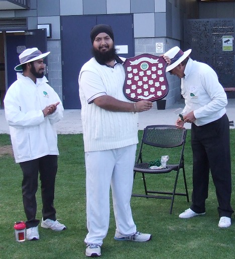 Captain Manu Singh receives the Premiership Shield from umpires Mehedi Hasan (left) and Lynn McFarlane-Smith.