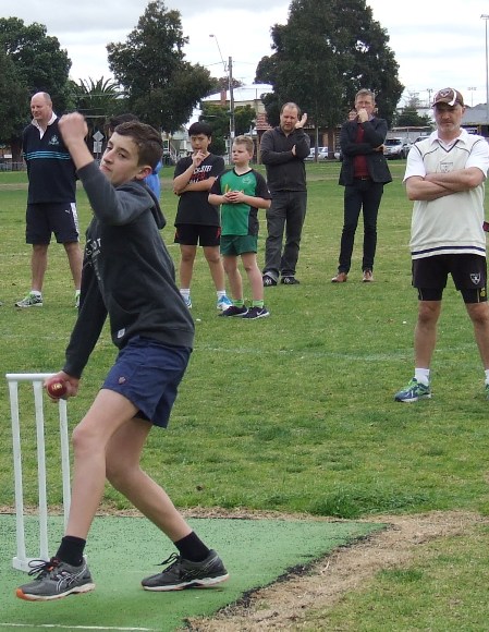 Luca Nimorakiotakis bowls in the southern nets, under the watchful eye of senior coach Lou Raffaele.