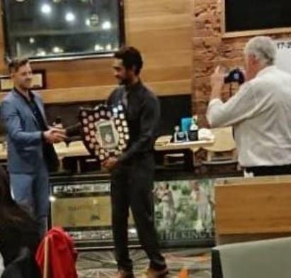 Club photographer Charlie Walker gets into the action as Matt Thomas (left) presents the Club Champion trophy to Chanaka Silva.