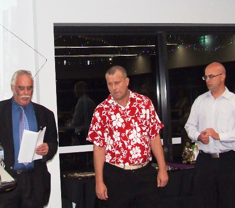 Life Member induction - Charlie Walker reads the citation for Shaun Rayment, while Mick Cumbo (right) waits to pin on his medallion.