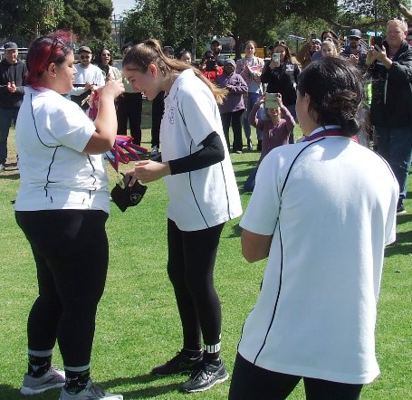 Captain Tanya Intagliata presents Tara Newman with her premiership medallion.