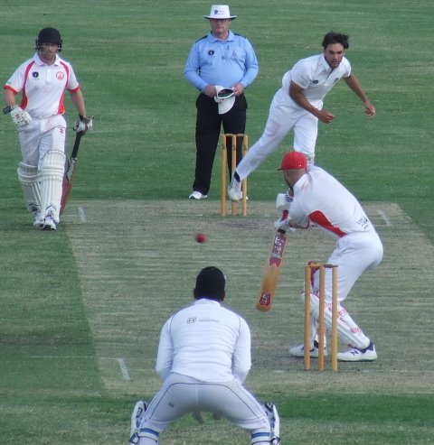 Luke Brock bowls in the GF, with Suraj Weerasinghe behind the stumps.