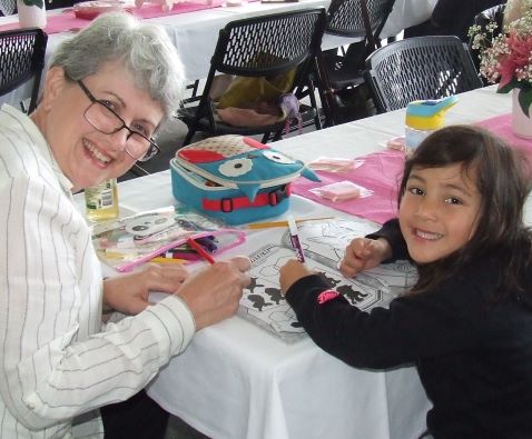 Nicole McLachlan helps Lexie Polonidis with coloring-in and puzzles.