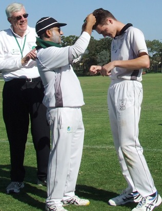 Young gun Tom Janetzki receives his premiership medallion - his first flag at any level - from skipper Sunny Sharma, with  umpire Graham Slater.