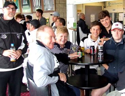 Ormond Park celebrations: Kevin Gardiner (left) and Daniel Comande stand behind te table, where player Jack Newman shares his game with Kris Garland and his parents, John and Janet.