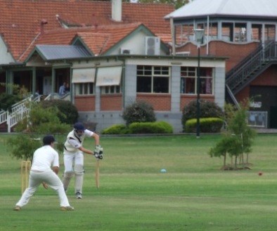 Matt Wenlock defends carefully, with the backdrop of the magnificent pavilion and tea rooms at the northern end of Fawkner Park, South Yarra.