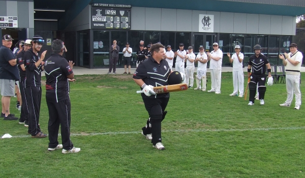 Club immortal Mark Gauci walks through an honor guard of teammates and clubmates as he sets off to open the innings in his 400th game.